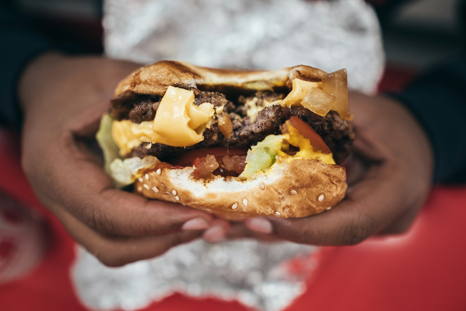 telling Cholesterol myth vs fact with a cheese burger in hand