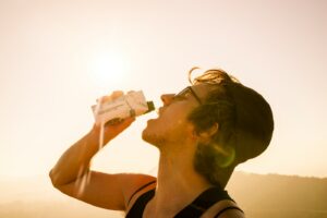 Person drinking from reusable water bottle